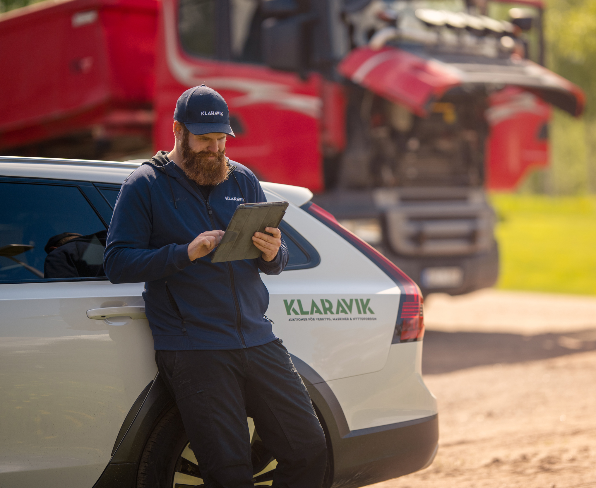 Auktionsmäklare som står framför en bil