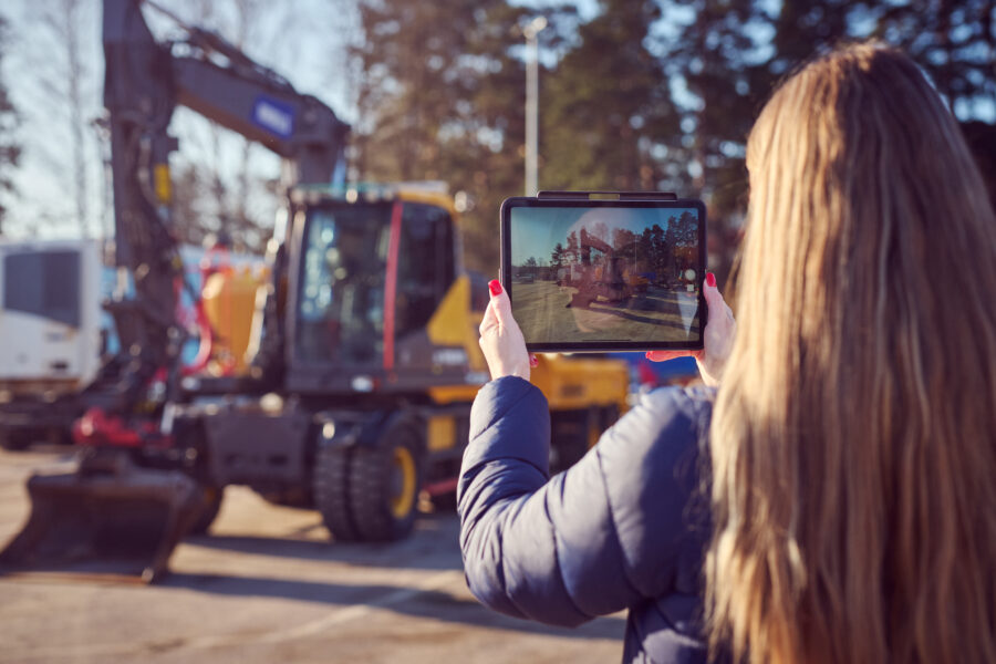 Auktionsm&auml;klare fotograferar en Volvo-gr&auml;vmaskin.